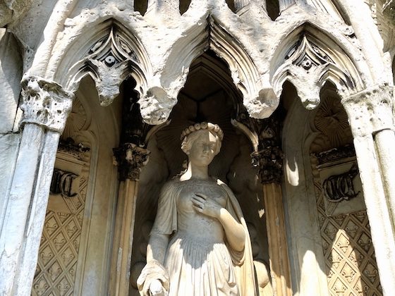 carved stone woman in green-wood cemetery monument
